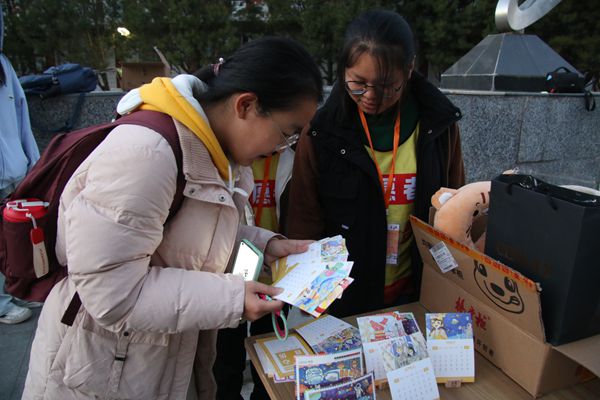 图三 志愿者们热情回答疑问并介绍纪念台历.jpg